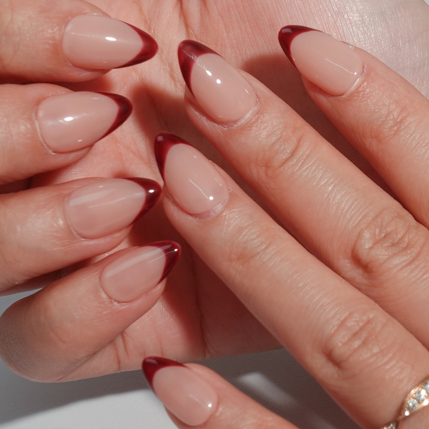 Deep brown French nails with almond-shaped design and smooth nude base, exuding noble elegance.