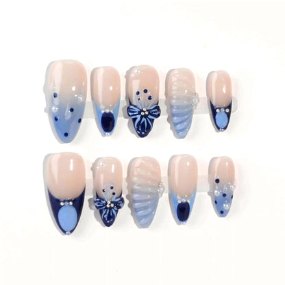 A mesmerizing set of handmade press-on nails with pink and navy hues, adorned with shimmering pearls, sculpted seashell elements, and elegant bows, evoking the tranquil beauty of moonlit ocean waves.