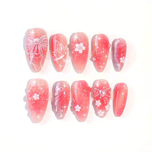 A charming set of handmade press-on nails adorned with intricate pink flowers, glittering details, and ethereal designs, radiating a soft, romantic glow.