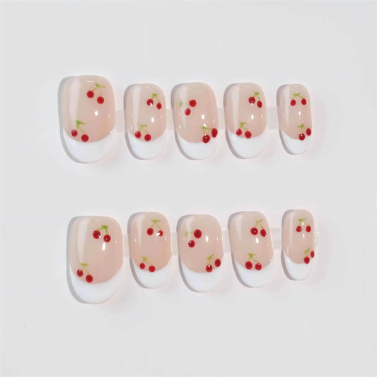 Nude nails with white French tips, beautifully decorated with dainty red cherries and green stems. This design captures the simplicity and elegance of a summer orchard, offering a graceful yet playful touch.