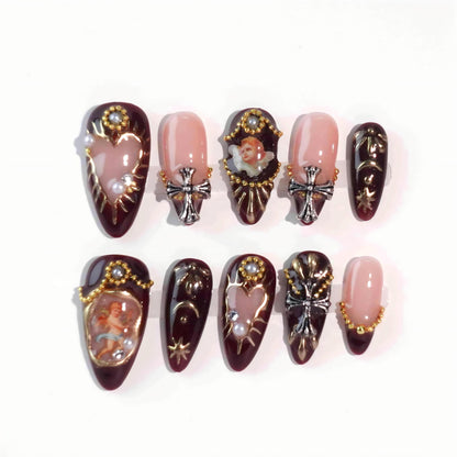 A luxurious set of burgundy press-on nails with golden details, pearl ornaments, hand-painted cherub motifs, and gothic-style crosses, evoking the grandeur and elegance of the Baroque era. Ideal for statement looks.