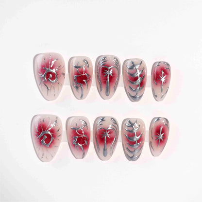 A striking press-on nail set with a red gradient background, adorned with silver metallic details, including abstract floral designs, delicate vines, and celestial star motifs. A perfect choice for a dramatic yet sophisticated look.