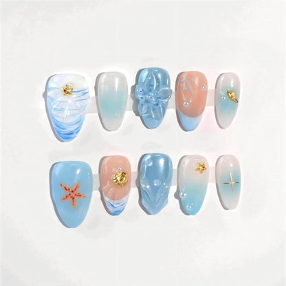 A set of handmade press-on nails showcasing soft blue and pastel gradients, detailed flower designs, starfish motifs, and pearl embellishments. These nails radiate an ocean-inspired elegance, perfect for a sophisticated and serene look.