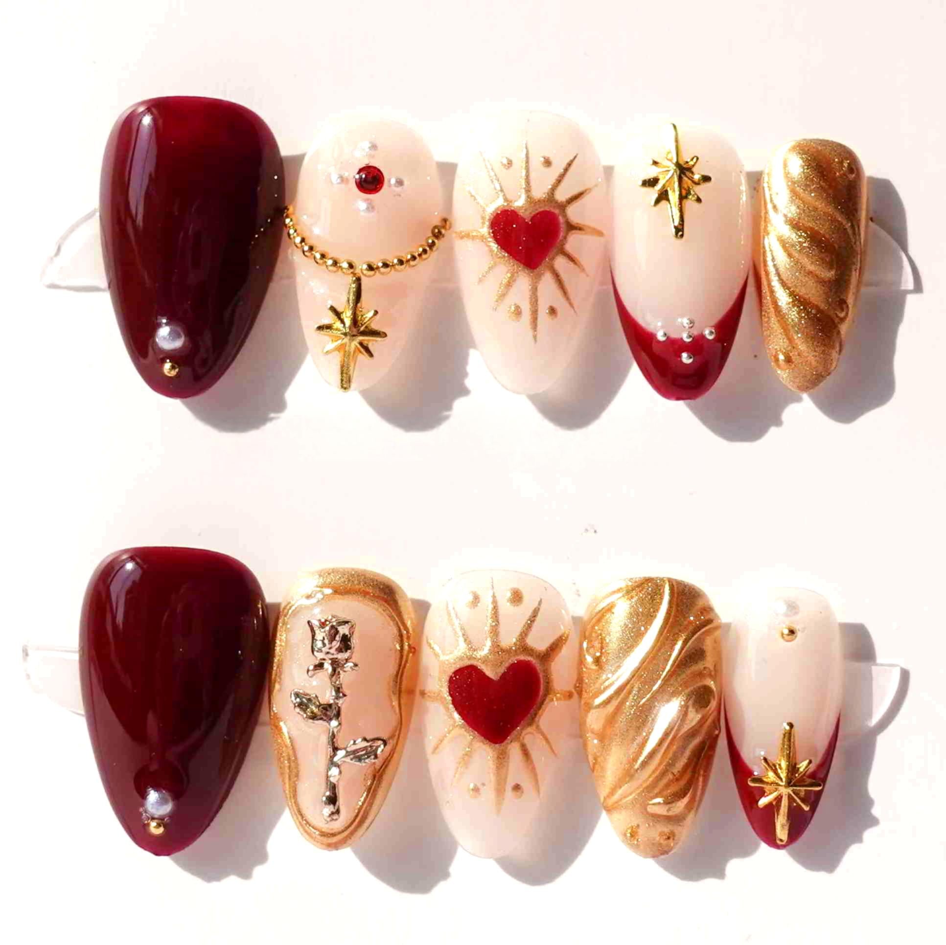 Press - on nails with golden accents, silver owl, deep red and soft pink background.