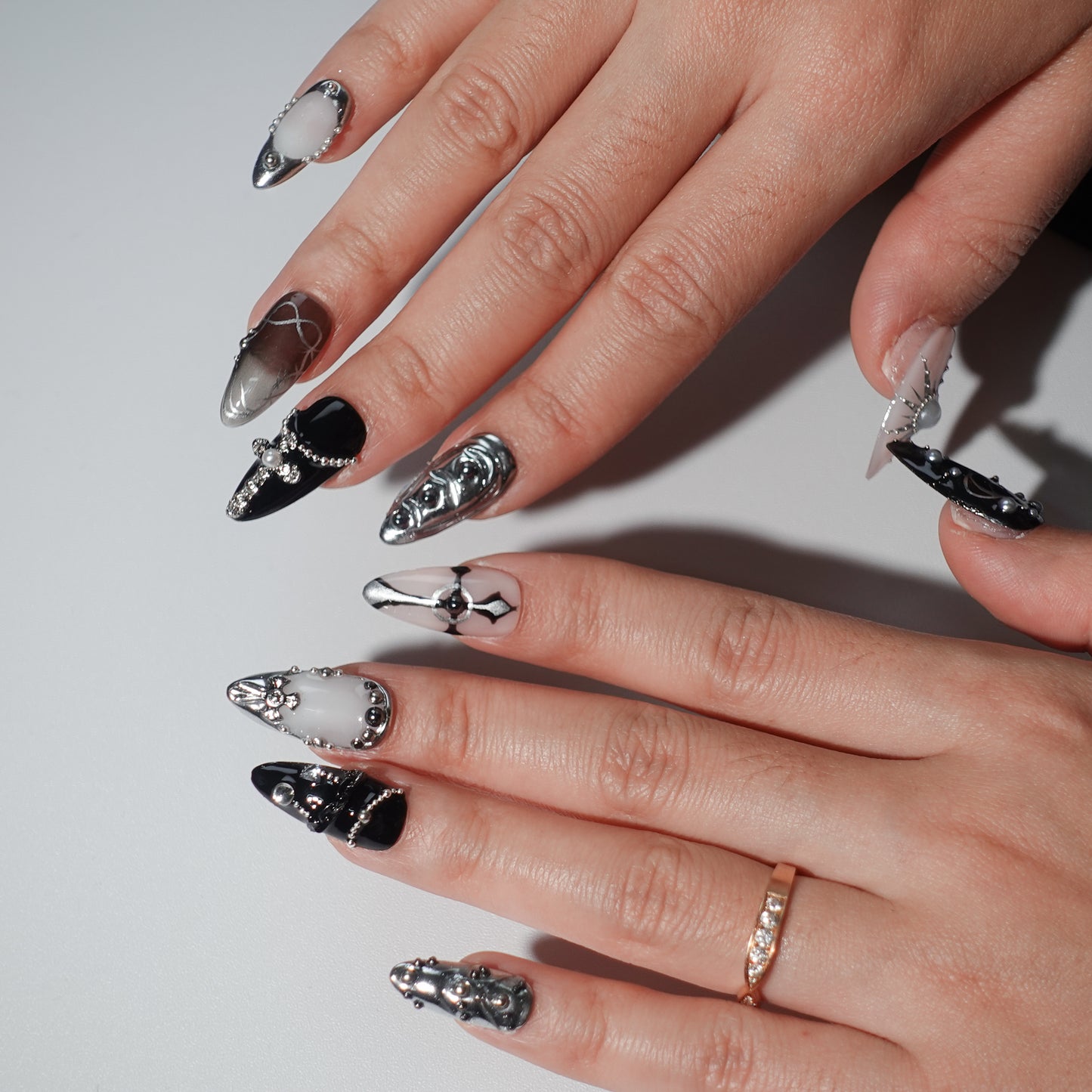 Press - on nails featuring dark hues, silver star - like accents, and a design that combines elements of Gothic style.