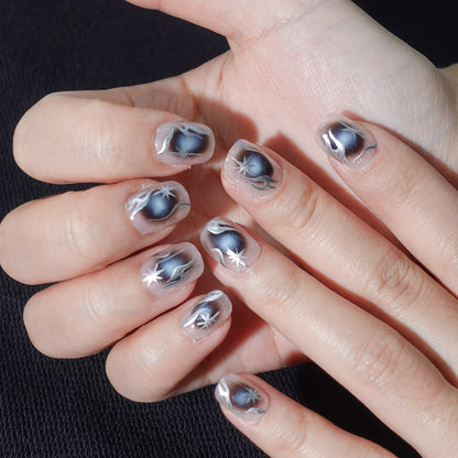 A set of handmade press - on nails with a dark - to - light gradient, featuring striking silver star - like designs. The nails have a bold, futuristic appearance, perfect for making a statement at night - time events or parties.