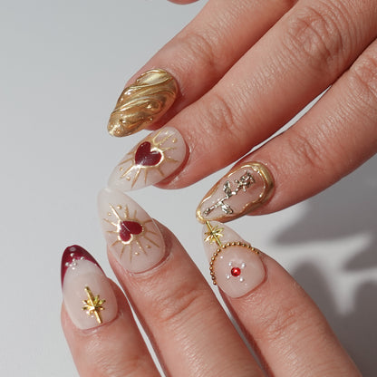 Press - on nails with golden accents, silver owl, deep red and soft pink background.