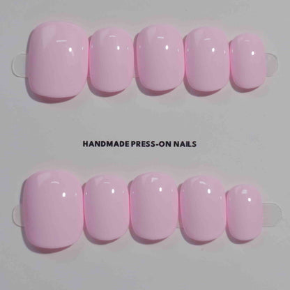 A set of light pink glossy press - on nails neatly arranged in a transparent case, featuring a gentle, smooth finish, ideal for romantic or feminine occasions.