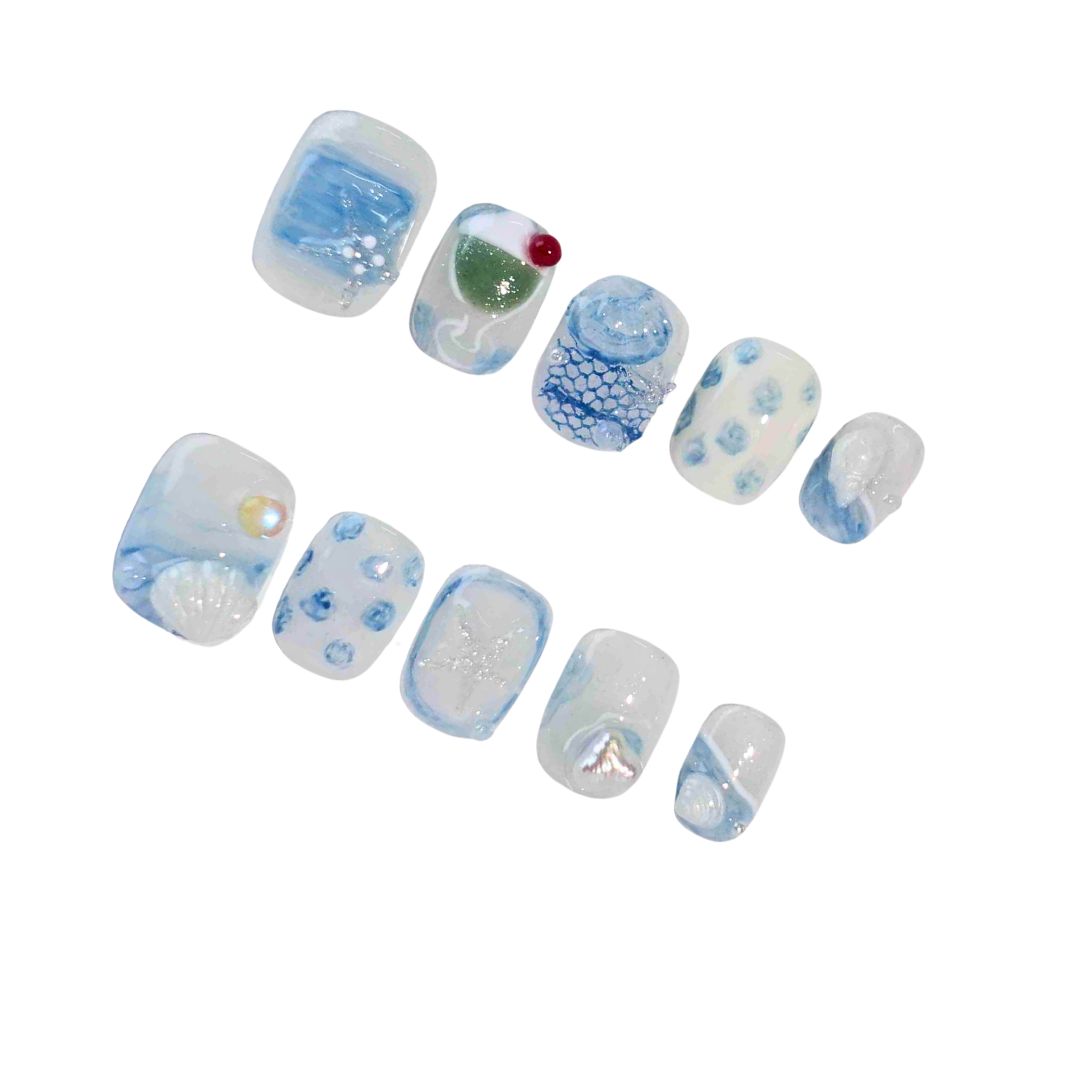 A captivating set of press-on nails in calming blue tones, featuring ocean-inspired designs such as seashells, delicate waves, and shimmering pearl details. Ideal for embracing a tranquil and sophisticated style.