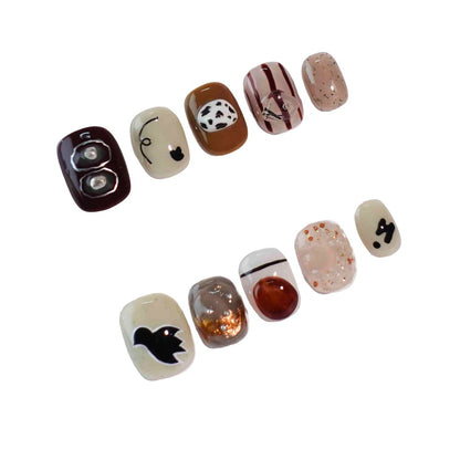 A stylish set of press-on nails blending warm earthy tones, abstract patterns, and creative details like cow prints, metallic accents, and playful animal shapes. Designed for those who love a blend of nature and artistry.