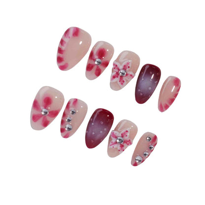 A set of press-on nails featuring a mix of soft pink and deep red tones, adorned with hand-painted floral designs and metallic silver embellishments. These nails create a romantic and chic aesthetic, ideal for evening events or celebrations.